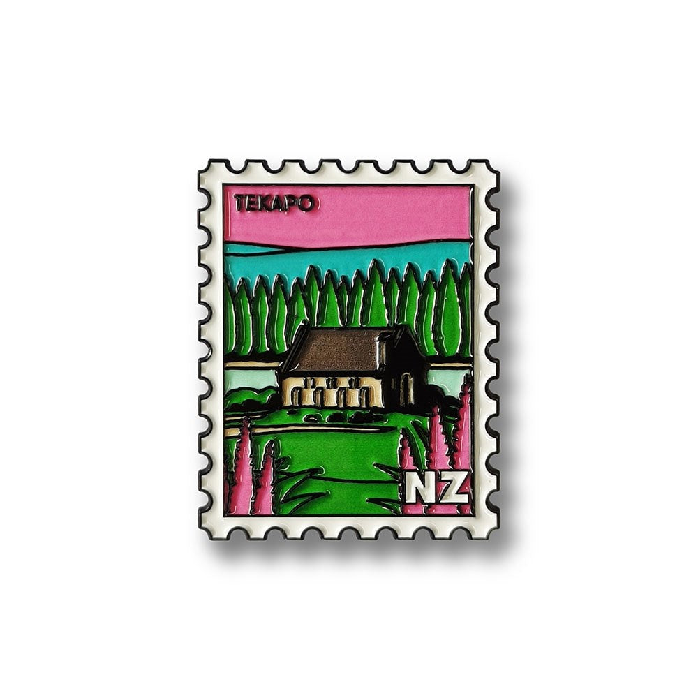 The Tekapo Collectible Stamp Magnet is a colorful Glenn Jones enamel pin, shaped like a postage stamp, showing a small church with trees and pink flowers. “Tekapo” is at the top with “NZ” in the corner—a charming New Zealand collectible.
