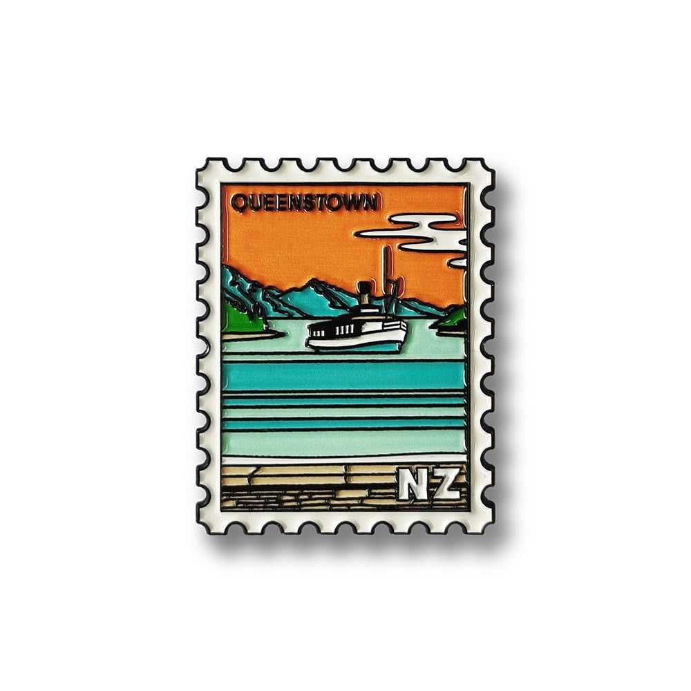 A Glenn Jones Artwork postage stamp-style design featuring a steamship on a turquoise lake, mountains, orange sky, and QUEENSTOWN text—perfect as the Queenstown Collectible Stamp Magnet.