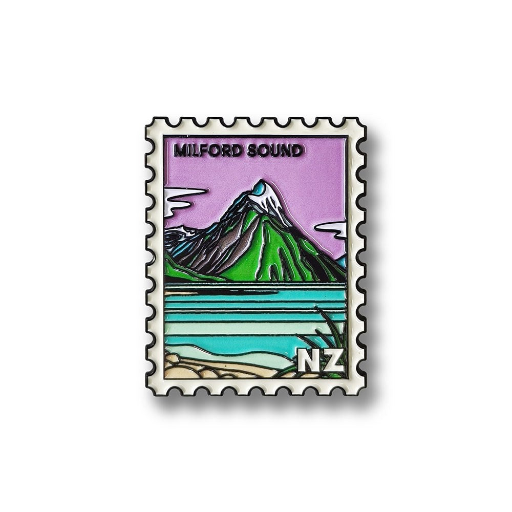 The Milford Sound Collectible Stamp Magnet showcases a Glenn Jones illustration of New Zealand’s Milford Sound, with green mountains, blue water, and a purple sky, plus “MILFORD SOUND” and “NZ” text—a perfect collectible.