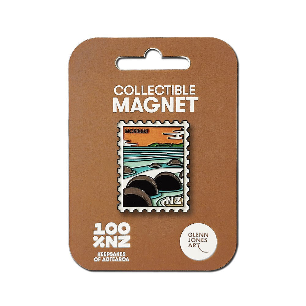 The Moeraki Collectible Stamp Magnet, designed by Glenn Jones, showcases the Moeraki Boulders at sunset. It comes in brown packaging labeled “100% NZ” and features the “Glenn Jones Art” brand.