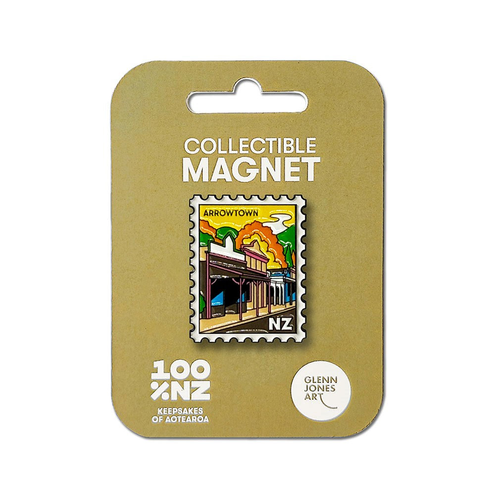 The Arrowtown Collectible Stamp Magnet is a rectangular enamel magnet designed to resemble a postage stamp and showcases a vibrant illustration of Arrowtown, NZ. It comes attached to a tan backing card labeled "Collectible Magnet" and "100% NZ Keepsakes of Aotearoa." This unique Arrowtown magnet is an ideal New Zealand souvenir for any collector.