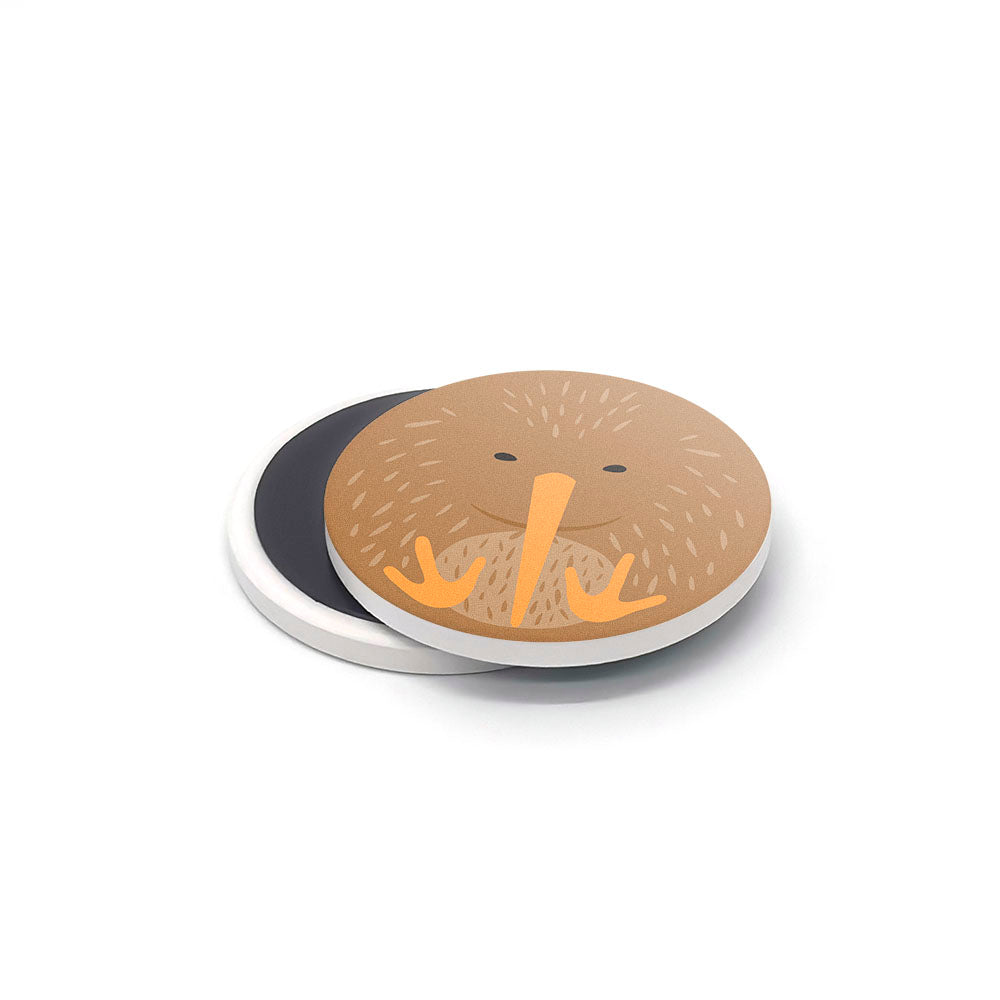Part of the NZ Cuties Ceramic Magnet Set, this round ceramic magnet features a brown kiwi with yellow beak and feet, overlapping its white circular backing, ideal as a New Zealand souvenir.