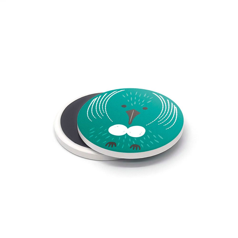 The NZ Cuties Ceramic Magnet Set features round printed ceramic magnets with green surfaces and stylized bird designs, each with a black underside—unique New Zealand souvenirs displayed on a white background.