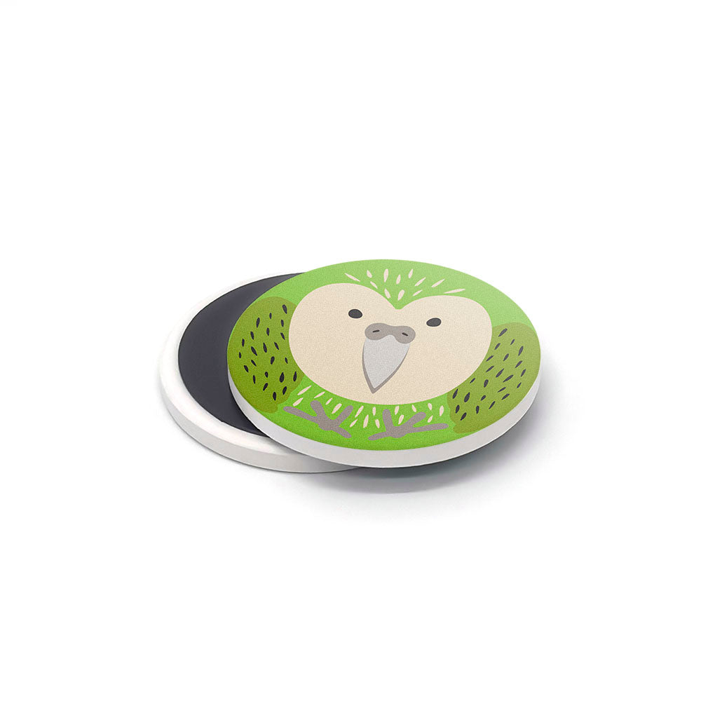 The NZ Cuties Ceramic Magnet Set features a round ceramic magnet with a green parrot illustration, large beak, and dotted markings on a white background—ideal as a charming New Zealand souvenir.