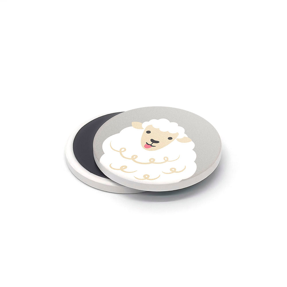 The Storybook Ceramic Magnet Set features a round, flat ceramic magnet with a cartoon sheep face and white wool on gray. A second, mostly white magnet is partly visible beneath them, both resting on a plain white surface.