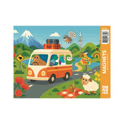 An illustrated scene features the Kiwi Road Trip Magnet Set: a red and white van with animals inside on a winding road, a sheep on a picnic blanket, birds flying nearby, plus mountains and flowers—a charming New Zealand souvenir.
