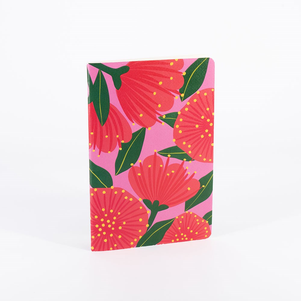 The Bright Botanical Notebook Set features a hand-stitched notebook with a pink cover adorned with bold red flowers, green leaves, and yellow dots, shown upright against a plain white background.