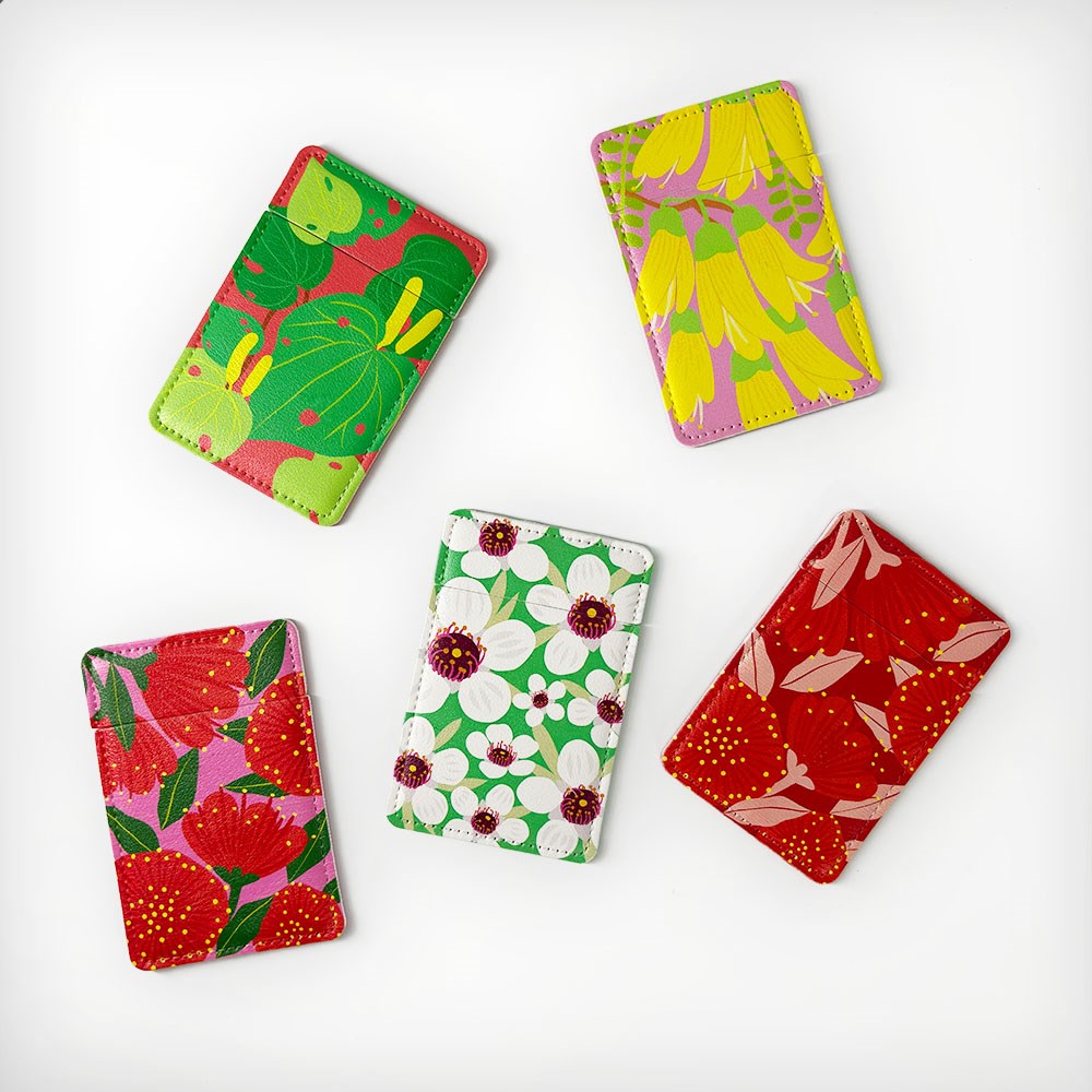 Five vegan leather cardholders with unique floral designs surround a Bright Botanical Kawakawa Pocket Mirror, all arranged on a white background. Each features vibrant vintage botanical patterns, ideal for cards or pairing with the pocket mirror.