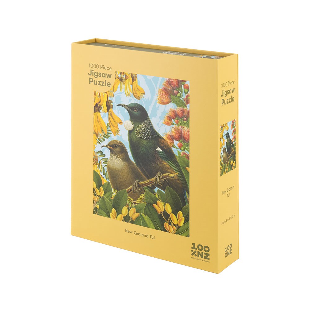 The Botanical Tui Jigsaw Puzzle Box is a yellow box containing a 1000-piece puzzle featuring two birds among yellow flowers, with 1000 Piece Jigsaw Puzzle and New Zealand Tui on the box—ideal for native bird jigsaw fans.
