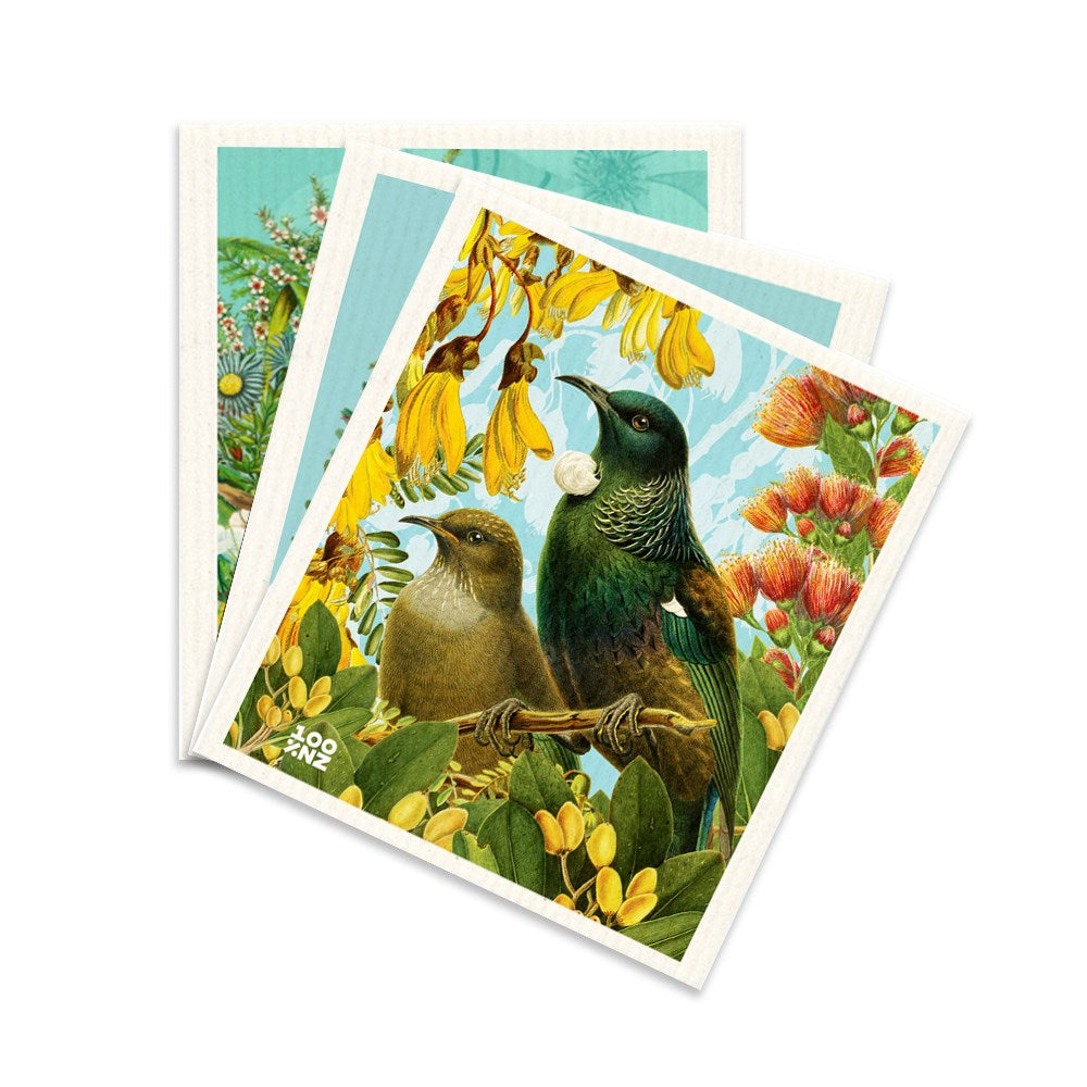 Three Swedish Dishcloths - Botanical Birds are stacked, the top showing two birds on a branch with yellow flowers and blue sky, while the others display eco-friendly botanical designs in blue, green, and red.