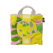 The Bright Kowhai Shopping Bag is a lightweight, reusable bag with yellow flowers and green leaves on a pink background. It folds up and has a round label that reads Shopping Bag.