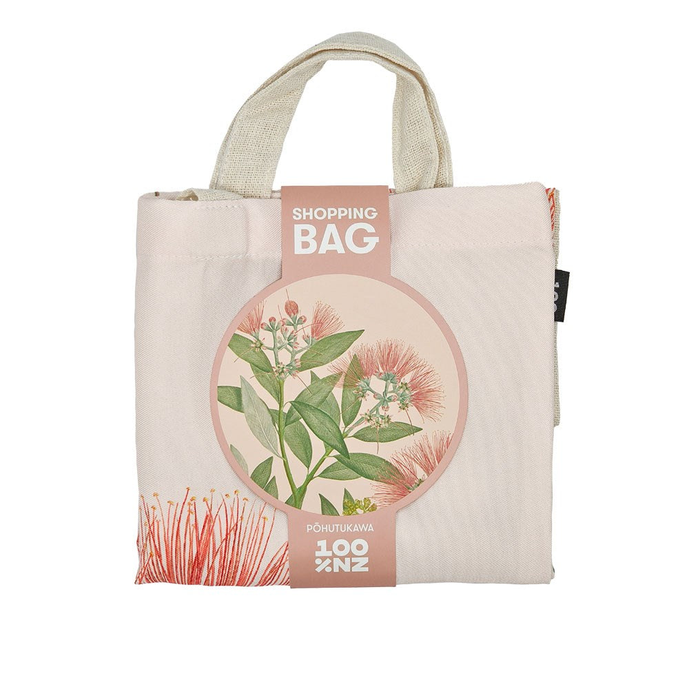 A folded affordable reusable shopping bag with short handles, packaged with a cardboard label featuring red pohutukawa flower illustrations and green leaves. The label reads Vintage Botanical Pohutukawa Shopping Bag and 100% NZ Pohutukawa.