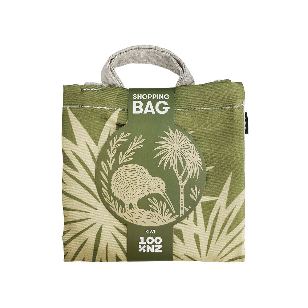 Folded olive green Woodcut Kiwi Shopping Bag featuring a circular print of a kiwi bird and palm trees, labeled Shopping Bag and 100% NZ.