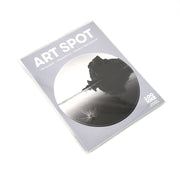 The Piha Art Spot is a sealed package featuring a black and white landscape photo of water and rock formations. Made in New Zealand, this repositionable wall art has a matte fabric finish and uses unique adhesive for easy application.
