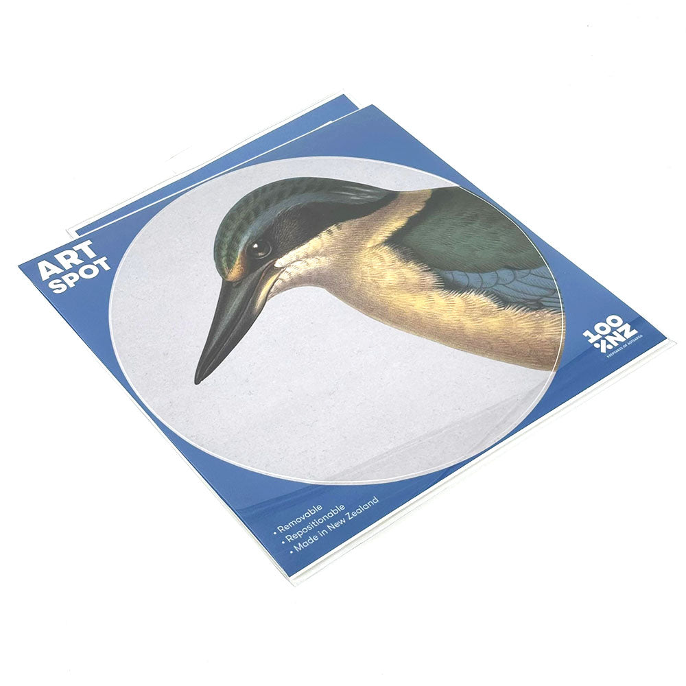 The Hushed Blue Kingfisher Art Spot is a square pad with a bird cover, labeled 100 ZIX. Made in New Zealand from recyclable materials, it features repositionable adhesive, perfect for custom wall art.
