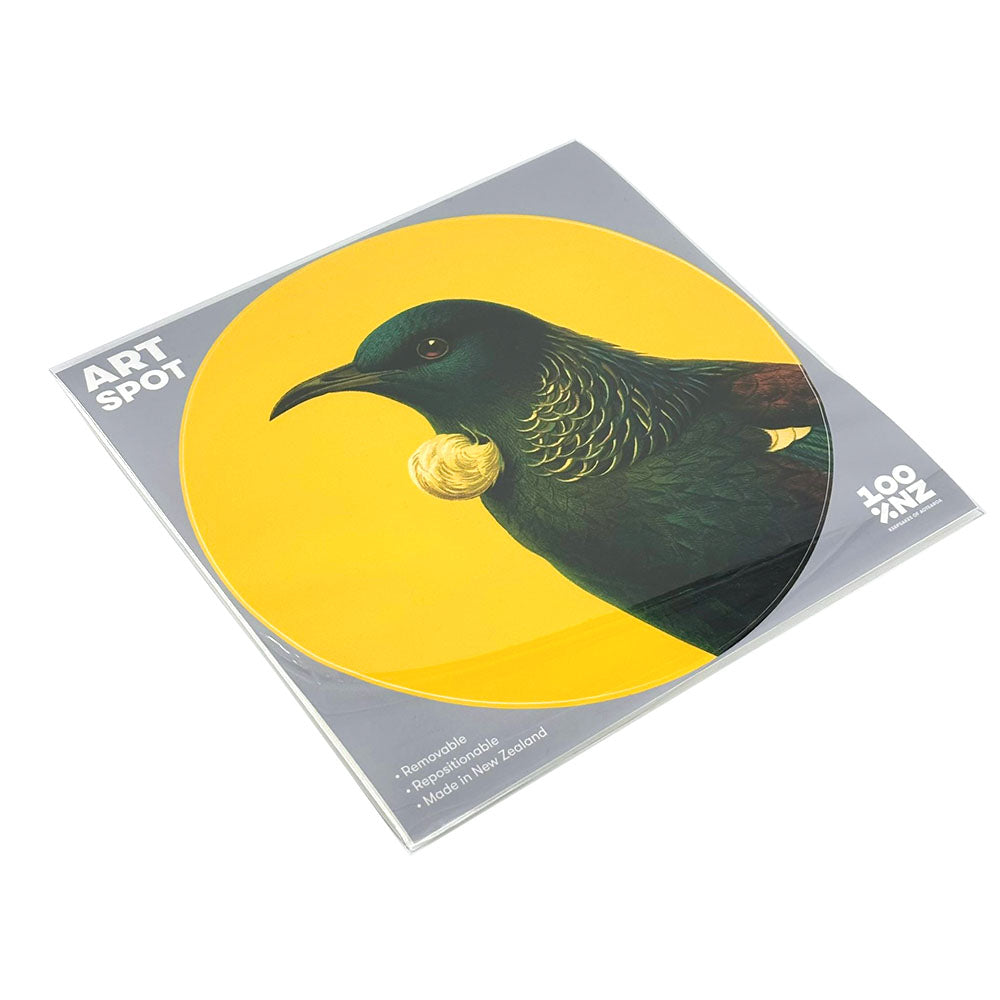 The Bright Tui Art Spot is a circular sticker with a tūī bird on yellow, packaged in a clear sleeve with grey ART SPOT card. This peel-and-stick, repositionable wall art is made in New Zealand and easy to apply or remove.