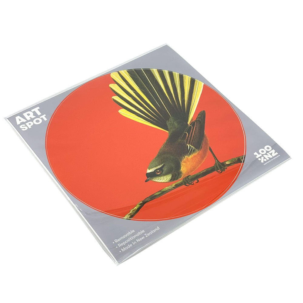 The Bright Fantail Art Spot is a round mouse pad with a bird and fanned tail illustration on an orange background, matte fabric finish, packaged in a clear sleeve labeled ART SPOT with details at the bottom right corner.