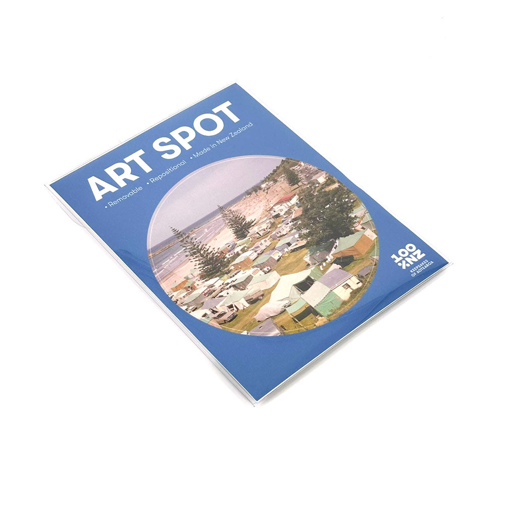 Retro Camping Art Spot is a magazine with a blue cover showing an aerial view of a coastal campsite with tents and caravans. It highlights Remarkable Inspiration Made in New Zealand and includes stunning matte-finish, repositionable wall art.