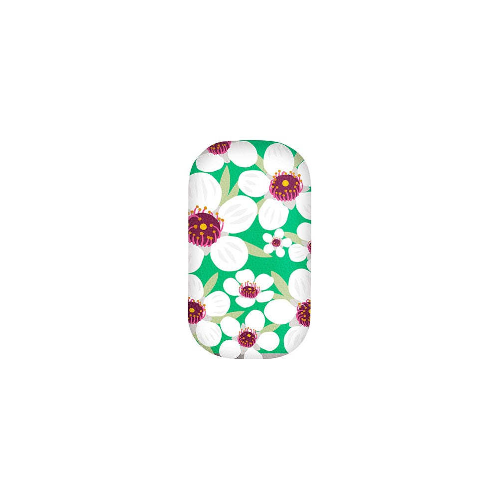 The Bright Botanical Manuka Trinket Box is a rectangular case with rounded edges, adorned with large white flowers with purple centers and green leaves on a vibrant green background.