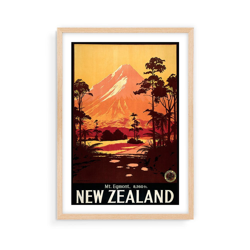 The Mt Egmont Tourist Print is a framed vintage-style archival poster of Mt. Egmont, New Zealand, featuring an orange sky, trees, and river with Mt. Egmont, 8,260 ft. NEW ZEALAND text—ideal for collectors of classic travel prints.