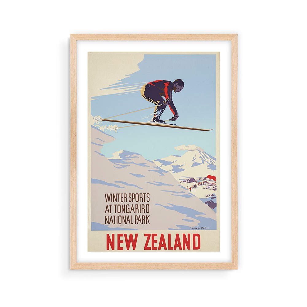 The Tongariro National Park Tourist Print is a framed vintage-style collectable poster of a skier mid-jump against snowy peaks and a pale blue sky, with the text: Winter Sports at Tongariro National Park, New Zealand.
