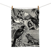 The NZ Stamp Tea Towel features a black and white illustration of four birds on branches and a frog amid foliage and mountains, screen printed on cotton. Designed in New Zealand, its shown clipped to a line with clothespins.