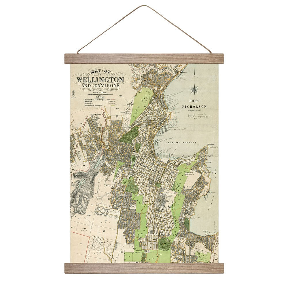 The Wellington Wall Chart is a vintage-style map of Wellington, NZ, highlighting streets, parks, and Port Nicholson. Featuring muted green, beige, and gray tones, it’s mounted between wooden bars with a string for easy hanging.
