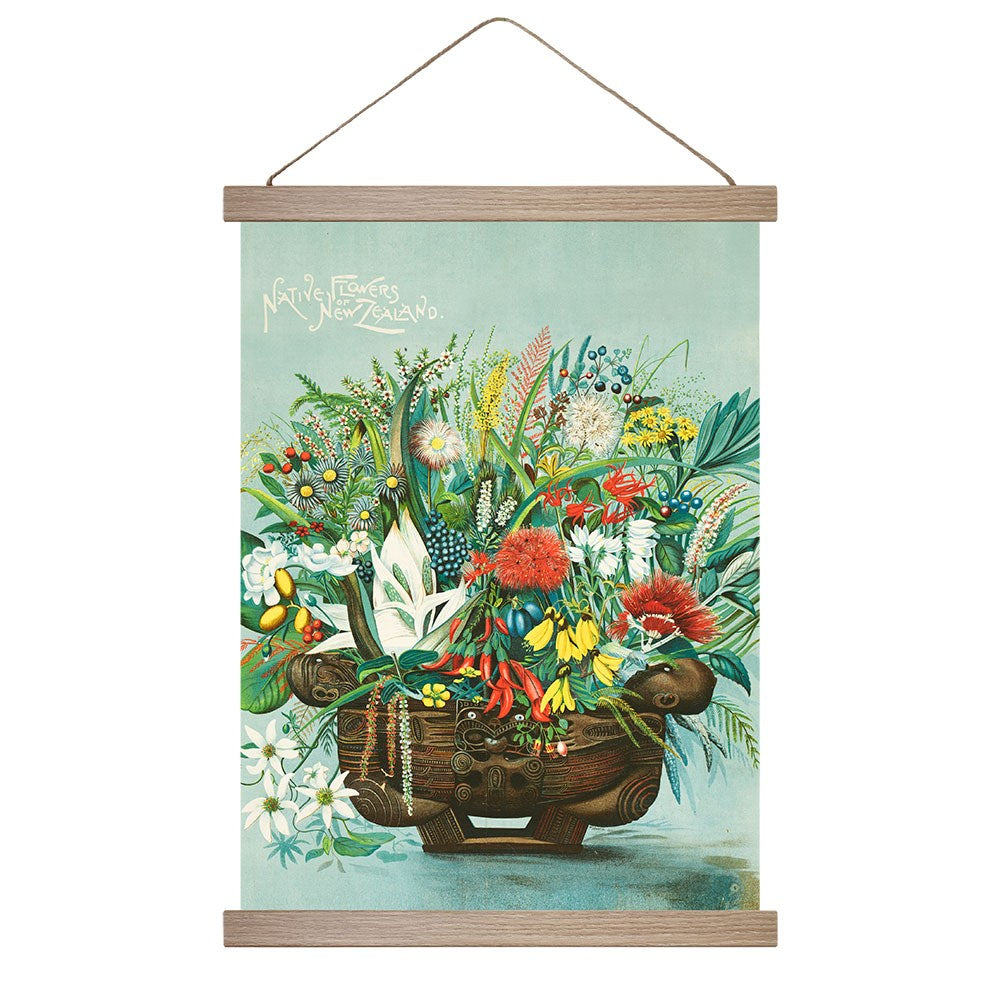 The Native Flowers Wall Chart features a print of colorful New Zealand native flowers in a carved wooden vessel, displayed in a vintage-style frame with string. Native Flowers of New Zealand appears in the top left corner.
