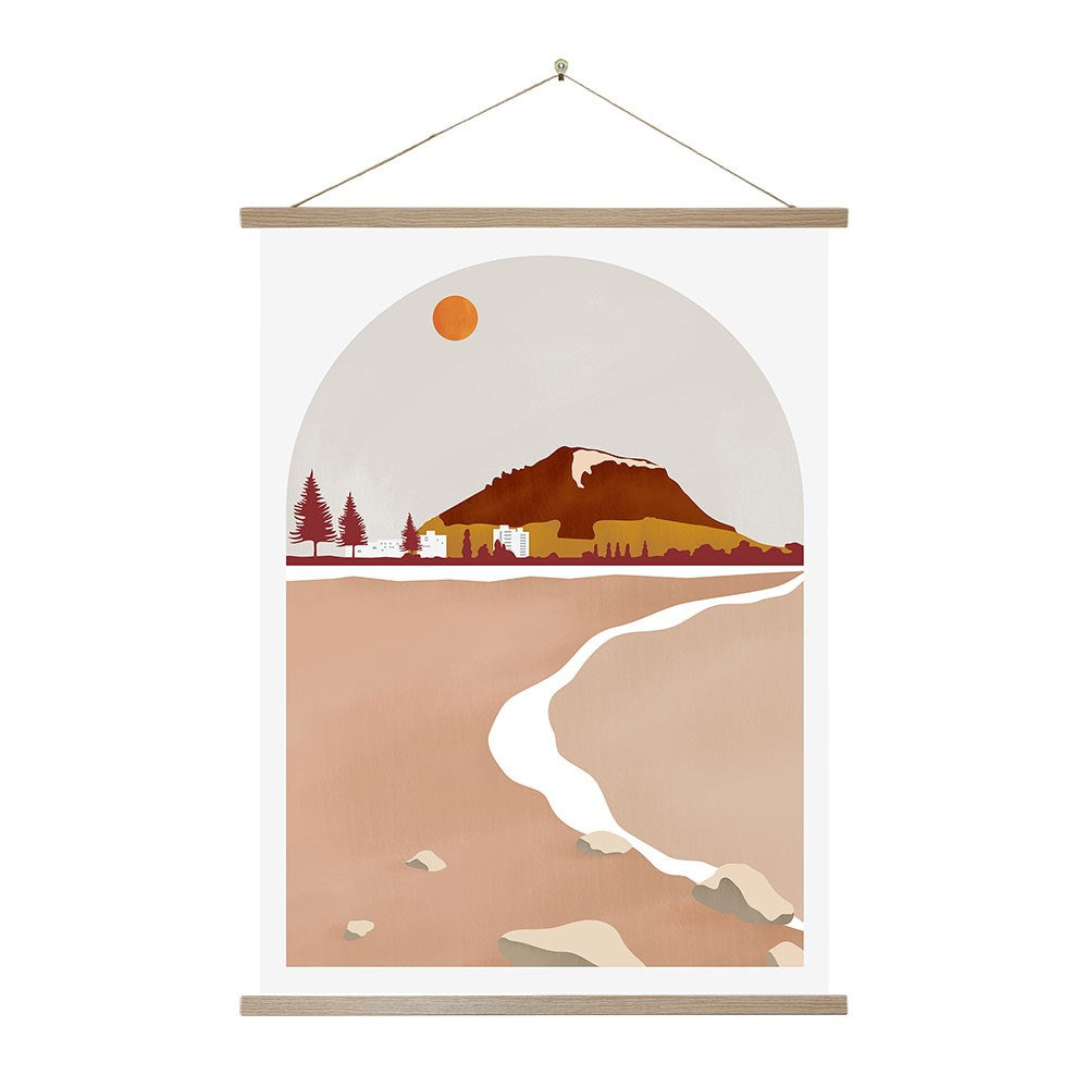 The Mt Maunganui Landmark Wall Chart showcases a minimalist New Zealand landscape with a mountain, trees, buildings beneath an orange sun, and a light path on brown terrain—all set in an arched frame. Ideal for instant art lovers.