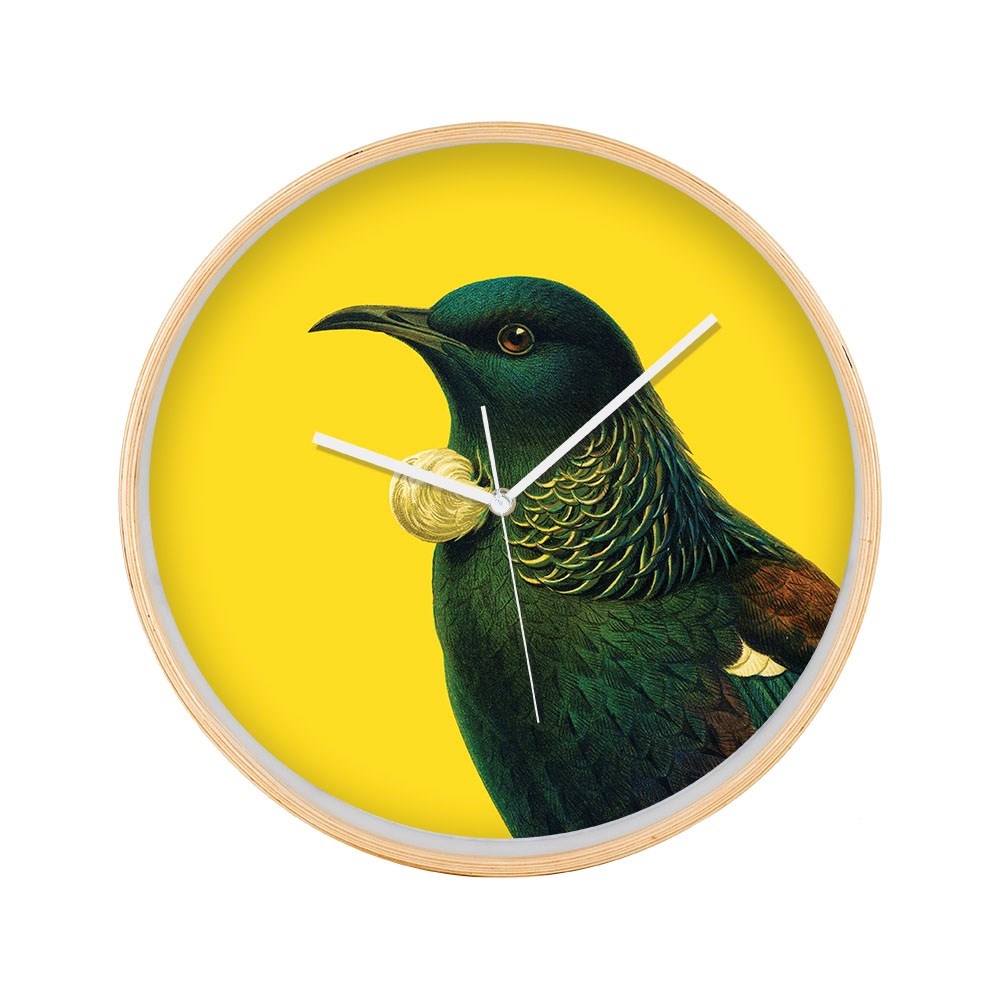 The Bright Tui Wooden Frame Clock is inspired by New Zealand, featuring a tui bird illustration on a vibrant yellow background. It has white hands, silent movement, no numbers, and a round wooden frame design.