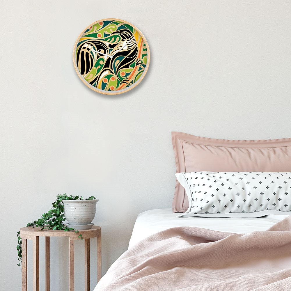 A Shane Hansen - Tui Wooden Frame Clock hangs above the bed with pink bedding and patterned pillows, while a small side table with a potted plant sits beside it, bringing a touch of New Zealand style to the light-colored room.