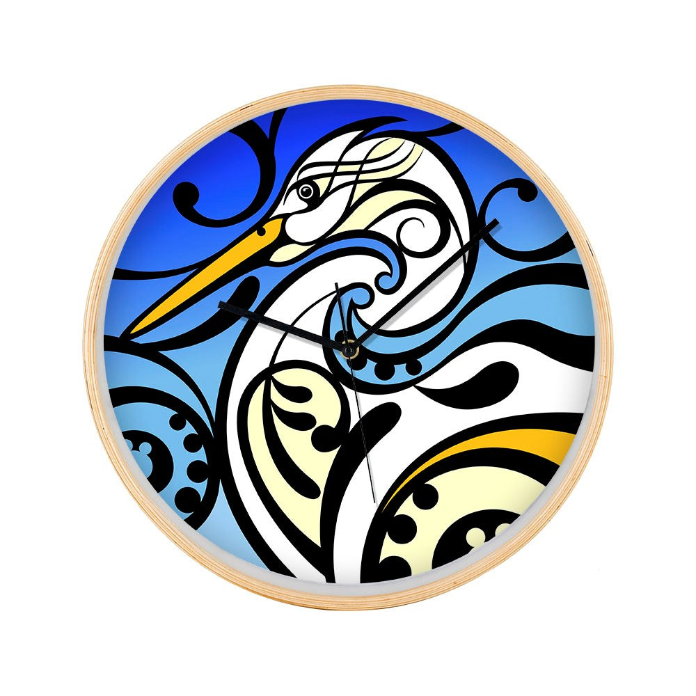The Shane Hansen - Kotuku Wooden Frame Clock showcases a stylized heron in black, white, yellow, and blue with swirling patterns on a blue gradient background. Features silent movement for accurate timekeeping.