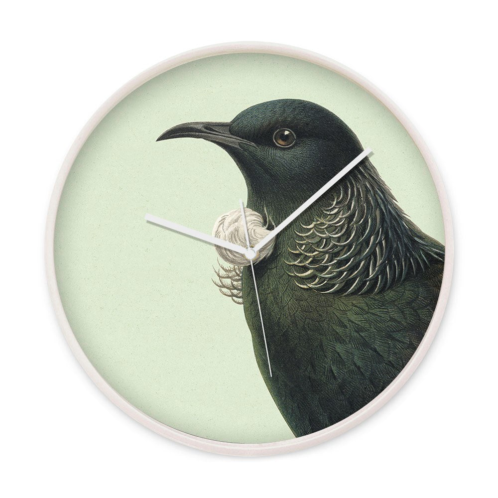 The Hushed Green Tui Wooden Frame Clock features a Native Tui bird with dark green plumage and white throat feathers on a pale green background, with simple white hands—a unique New Zealand accent for your wall.