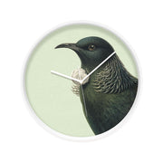 The Hushed Green Tui Wooden Frame Clock - Second features New Zealands native tui with iridescent green feathers on a light green background, displayed in a round wooden frame and designed for silent movement. The time shown is 7:22.