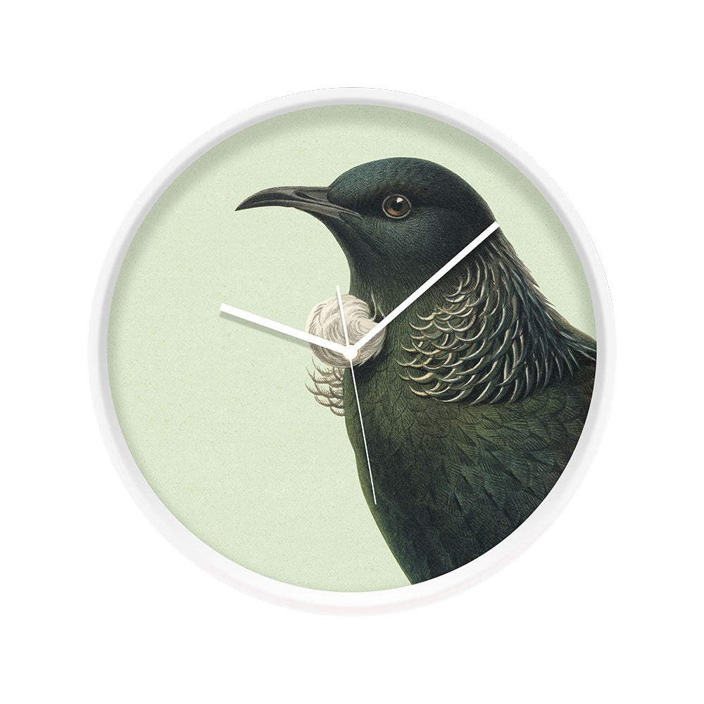 The Hushed Green Tui Wooden Frame Clock - Second features New Zealands native tui with iridescent green feathers on a light green background, displayed in a round wooden frame and designed for silent movement. The time shown is 7:22.