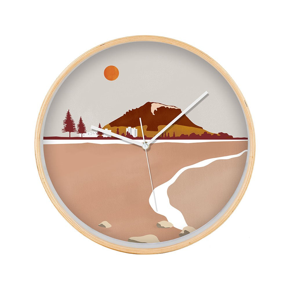 The Mt Maunganui Landmark Wooden Frame Clock features a mountain, trees, building, and river beneath a reddish sun in warm brown and beige tones, inspired by the scenery of Mt Maunganui, New Zealand.