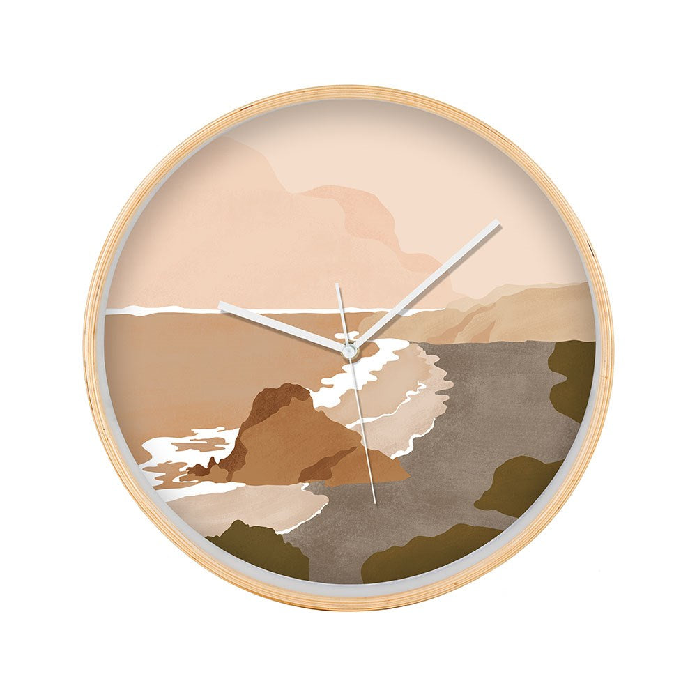 The Piha Landmark Wooden Frame Clock features a beige round frame and an abstract illustration of NZ’s iconic Piha coastline in muted earth tones, with white hour, minute, and second hands.