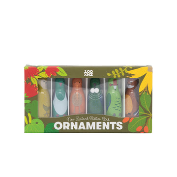 The Box of Native Bird Ornaments is a gift set of five colorful New Zealand bird Christmas ornaments, each upright in a green and yellow floral box labeled ORNAMENTS.