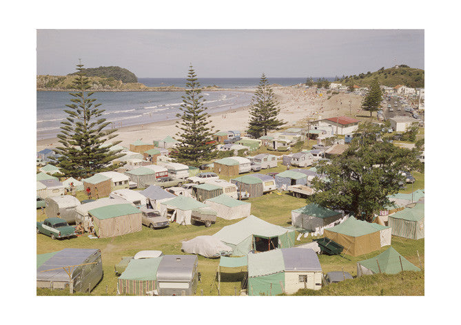 Enjoy the spirit of camping at Mt Maunganui with the Retro Camping Print—a photographic print on archival quality matte paper. It features a large campsite with tents, campers, pine trees, and people relaxing by the sandy beach.