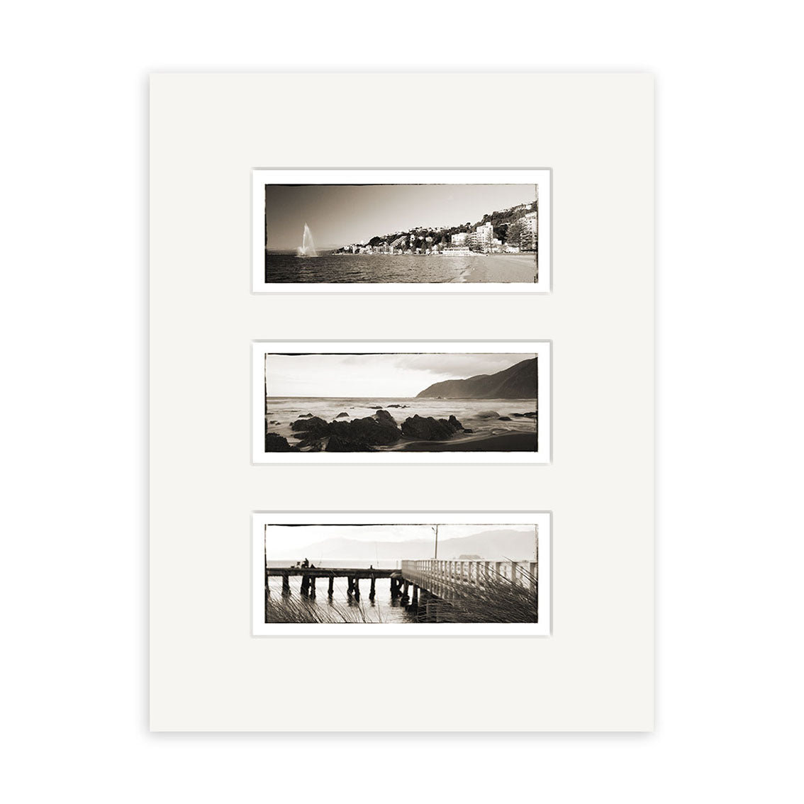 A white mat displays Wellington Triptych - RP105: three horizontal black and white Reuben Price photos—a coastal town, a rocky New Zealand shoreline, and people on a pier.