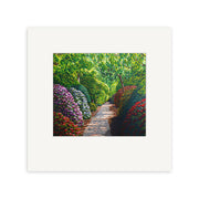 The Karl Maughan Riverhead Small Art Print features a garden path bordered by vibrant red, purple, and white flowers, with green trees overhead and sunlight filtering through the leaves.