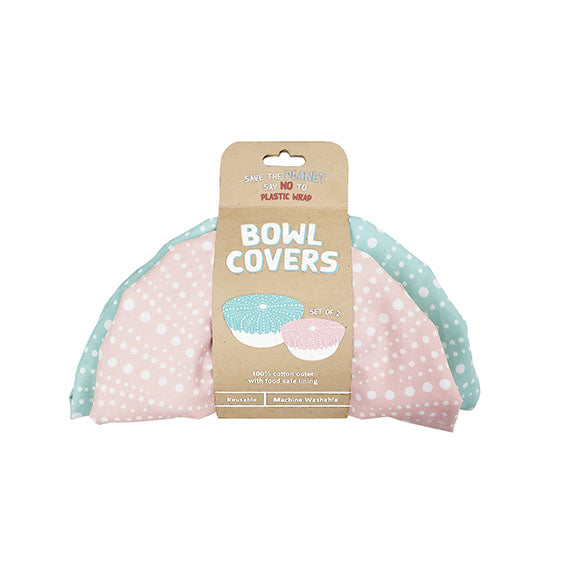 The Kina Bowl Covers (Set of 2) include one pink and one light blue cotton bowl cover with white polka dots. Both are food-safe certified, reusable, machine washable, and come with a cardboard label reading Bowl Covers. Set of 2.