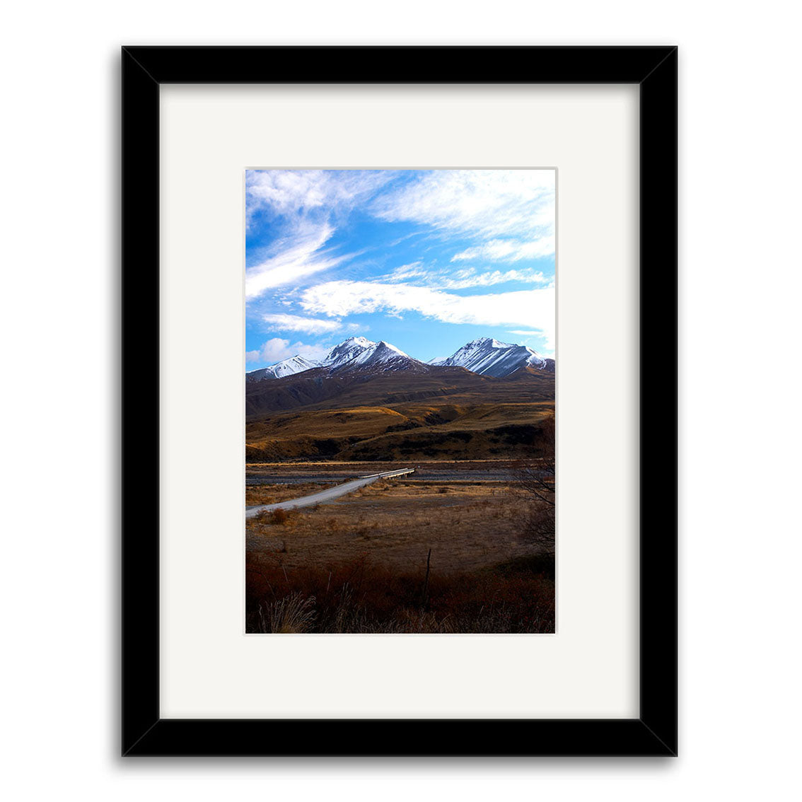 The Mt Potts - RP065 framed print features a New Zealand mountain landscape with snow-capped peaks, a winding river, and grassy plains under a blue sky. Printed on archival matte paper with a black frame and white mat.