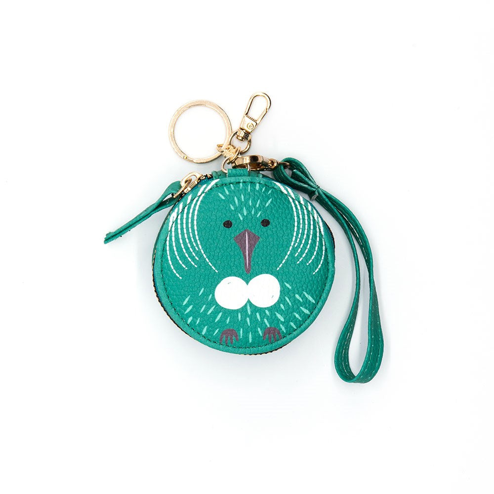 The Tui Cutie Coin Purse is a round green pouch with a cute tui bird face, gold keychain, and matching wrist strap. Inspired by New Zealand, its perfect for fans of whimsical coin purses and unique bird designs. Photographed on white background.