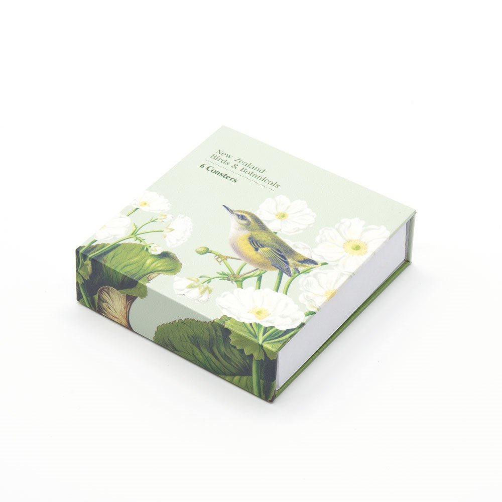 The Birds & Botanicals of NZ Set of 6 Coasters comes in a decorative square box featuring a bird perched on white flowers and green leaves. The slightly open box reveals the set of six stylish coasters inside.