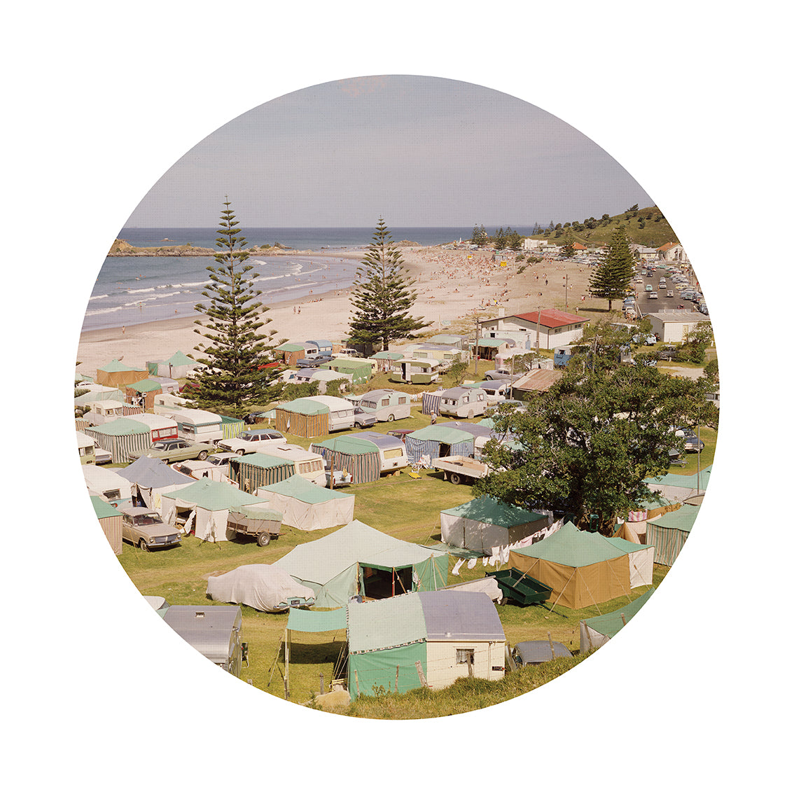 Retro Camping Art Spot: Repositionable wall art with a matte fabric finish brings charm to a coastal campground of tents and caravans nestled by a sandy beach, surrounded by tall pines and grassy areas.