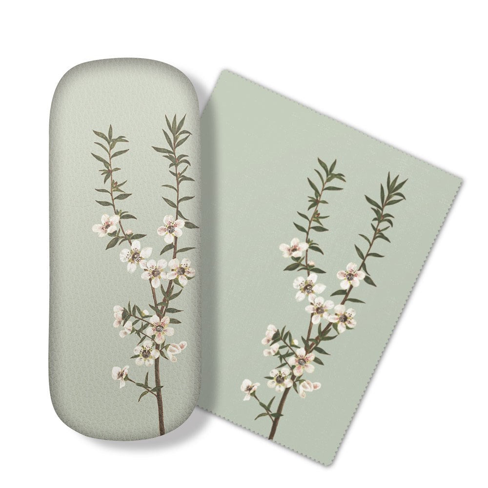 The Vintage Botanical Manuka Glasses Case features a light green case and matching micro-fibre cloth, both adorned with illustrations of flowering branches, perfect for cleaning your glasses or electronics screens.