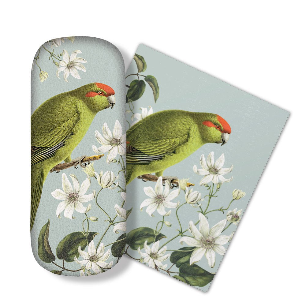 The Birds & Botanicals Kakariki Glasses Case comes with a matching micro-fibre cloth featuring a green parrot with a red forehead on a branch with white flowers—ideal for cleaning glasses or electronic screens.