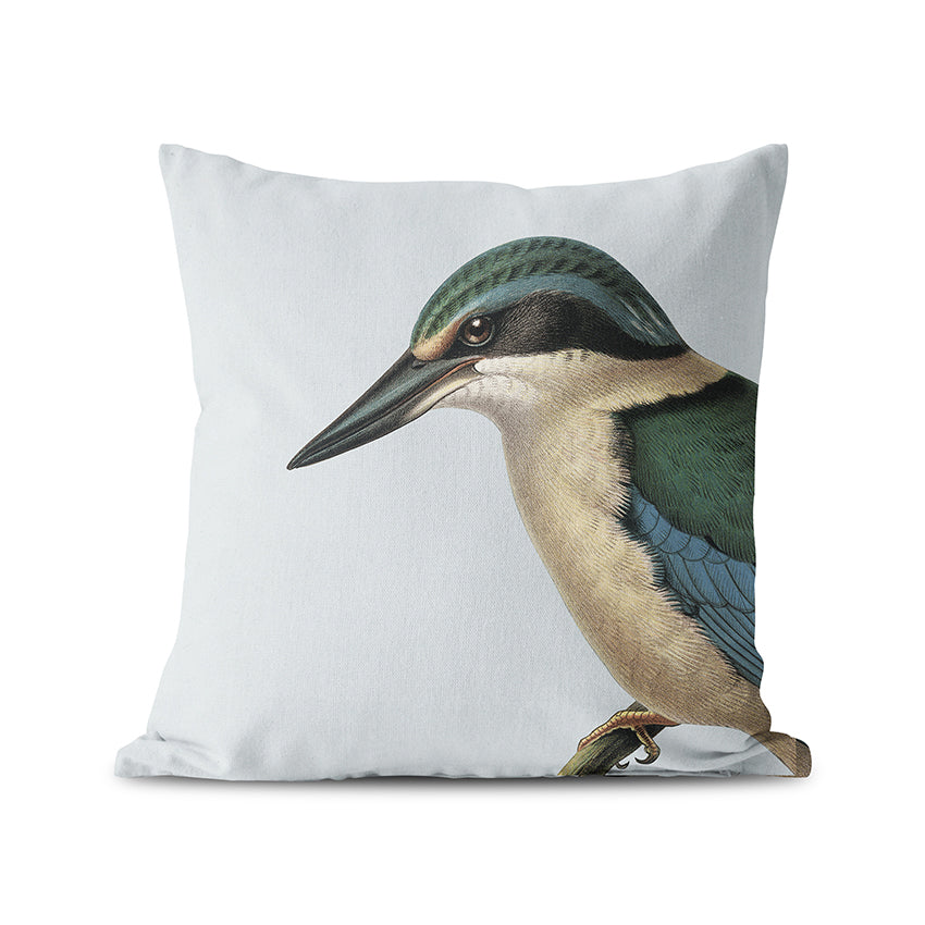 The Hushed Blue Kingfisher Cushion Cover features a detailed kingfisher illustration in blue, green, and beige on a plain white background, inspired by New Zealand native birds with a soft suede-feel finish.