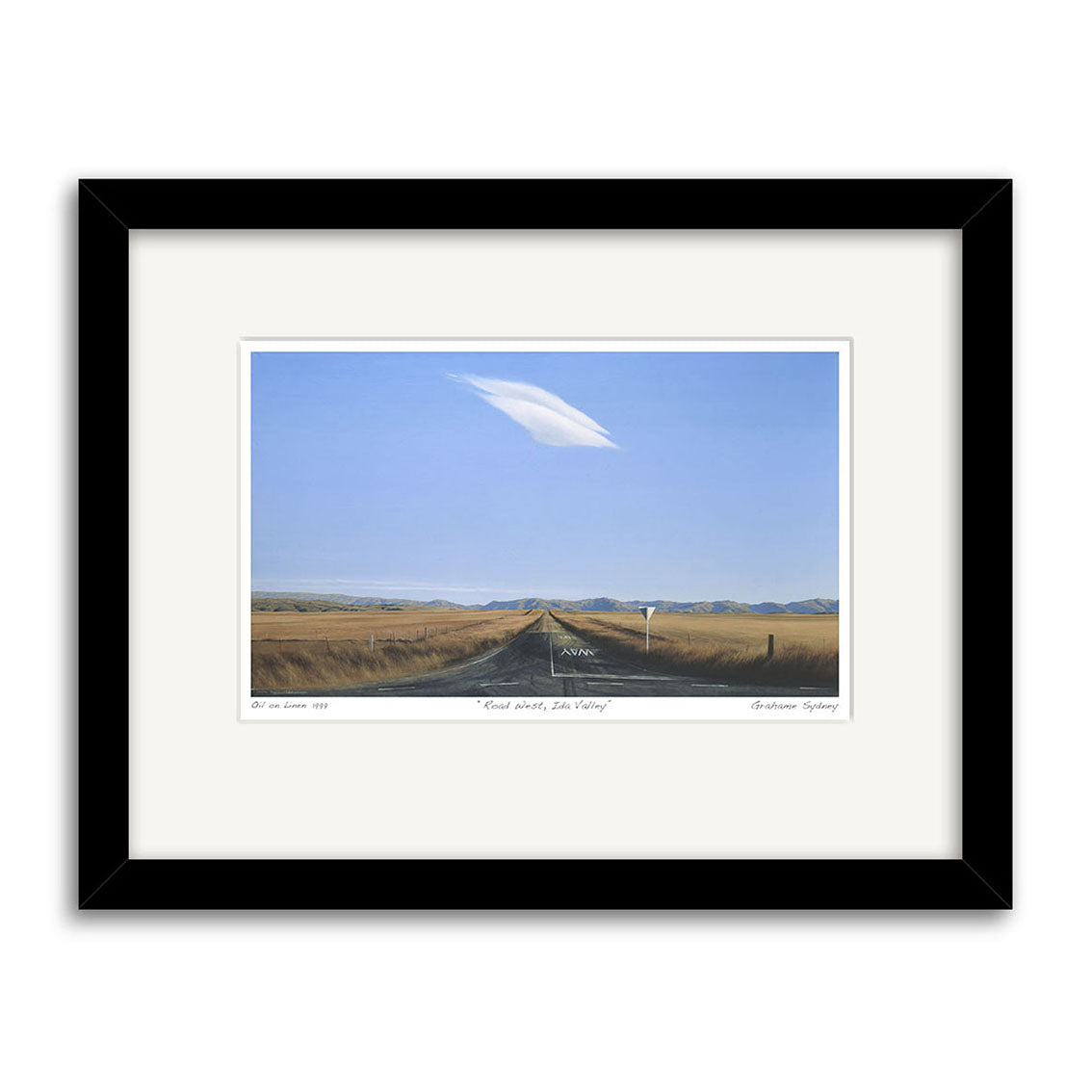 The Grahame Sydney - Road West, Ida Valley Small Art Print features a two-lane road running through open fields beneath a bright blue sky with one long white cloud and distant mountains, echoing Sydneys iconic style.